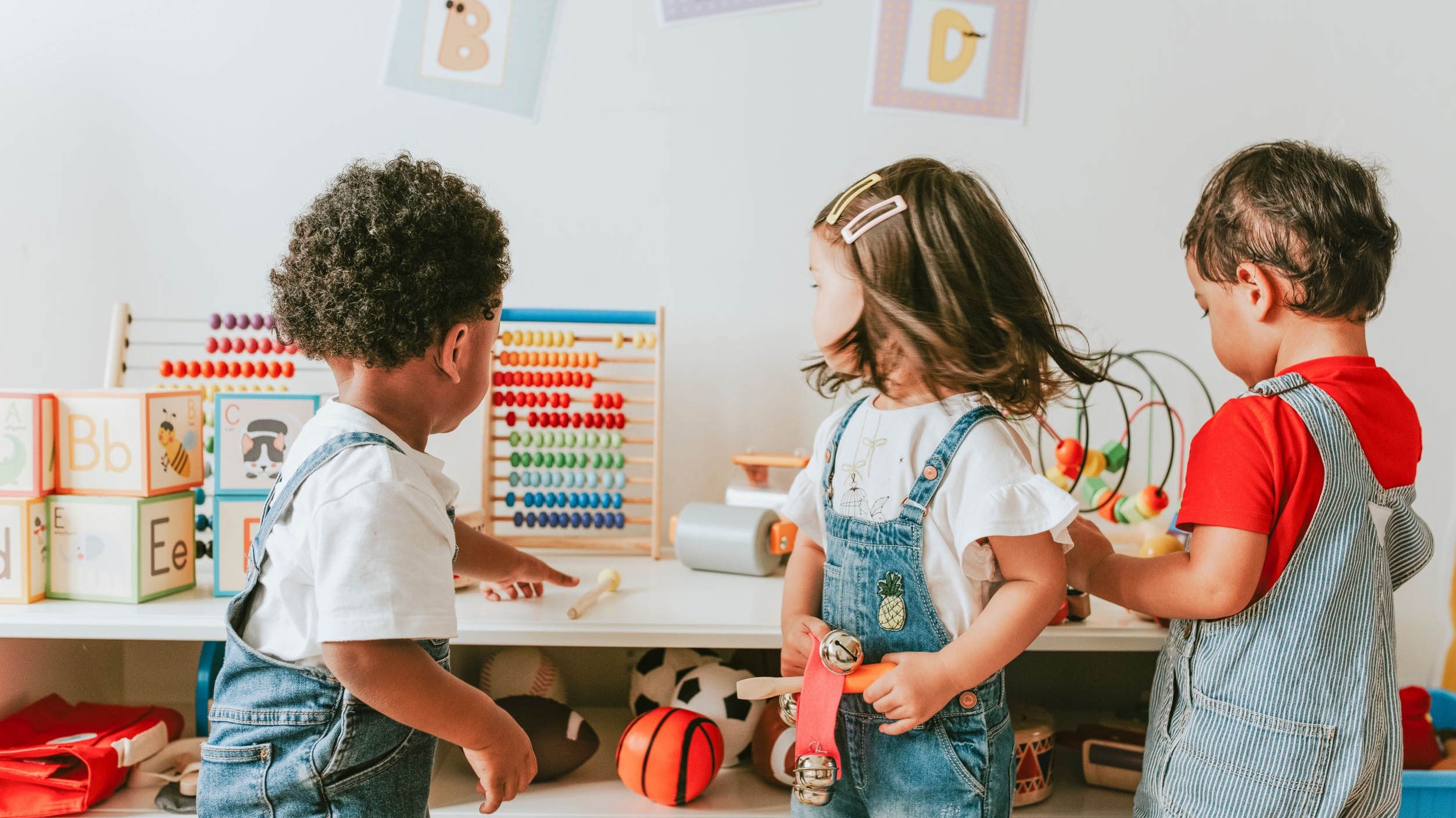 Three young children playing in a childcare centre