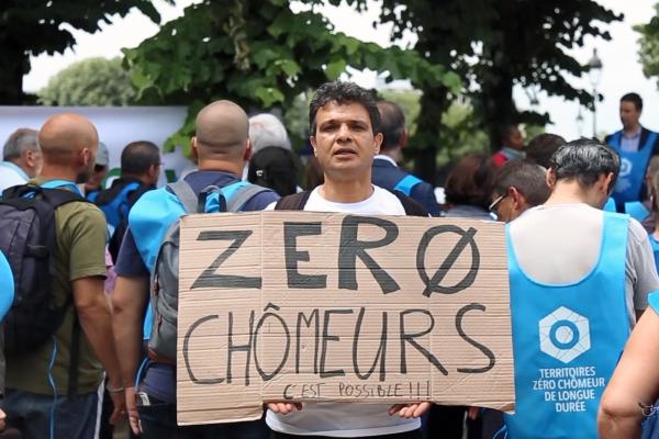 A man showing a message calling for zero long-term unemployment